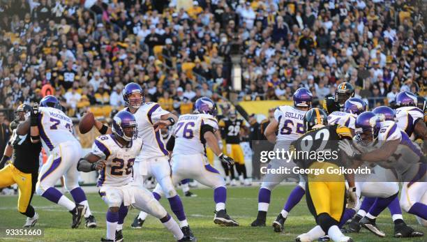 Quarterback Brett Favre of the Minnesota Vikings passes behind the blocking of running back Adrian Peterson, wide receiver Visanthe Shiancoe and...