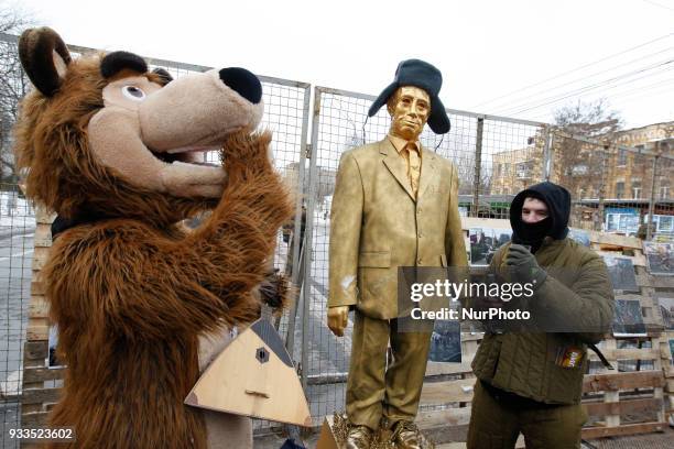 Ukrainian nationalists perform with a figure depicting Russian President Vladimir Putin, during a protest to block access for Russian citizens who...