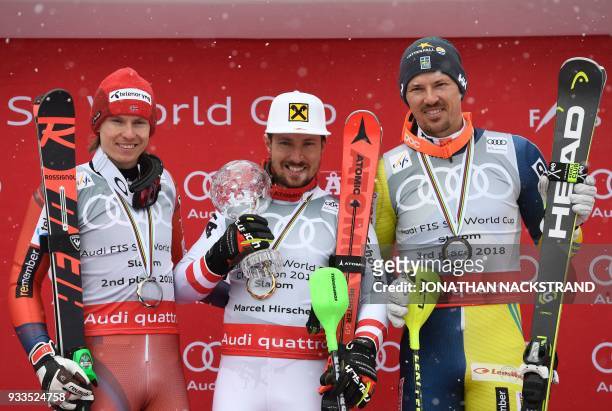 Overall winners of the Men's Slalom discipline of the Alpine Skiing World Cup pose on the podium Henrik Kristoffersen of Norway, Marcel Hirscher of...