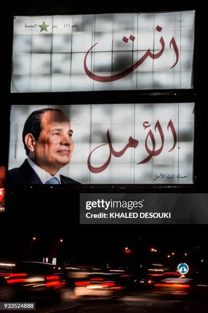 Long exposure picture taken on late night of March 17 shows a giant election campaign board supporting Egyptian President Abdel Fattah al-Sisi in the...