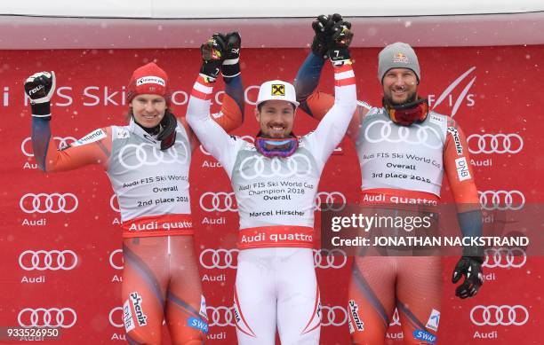 Overall winners of the Men's Alpine Skiing World Cup celebrate on the podium Henrik Kristoffersen of Norway, Marcel Hirscher of Austria and Aksel...