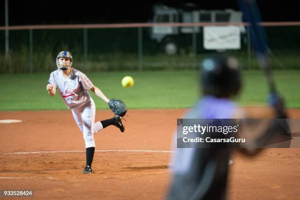 softball pitcher throwing the ball to batter - softball stock pictures, royalty-free photos & images