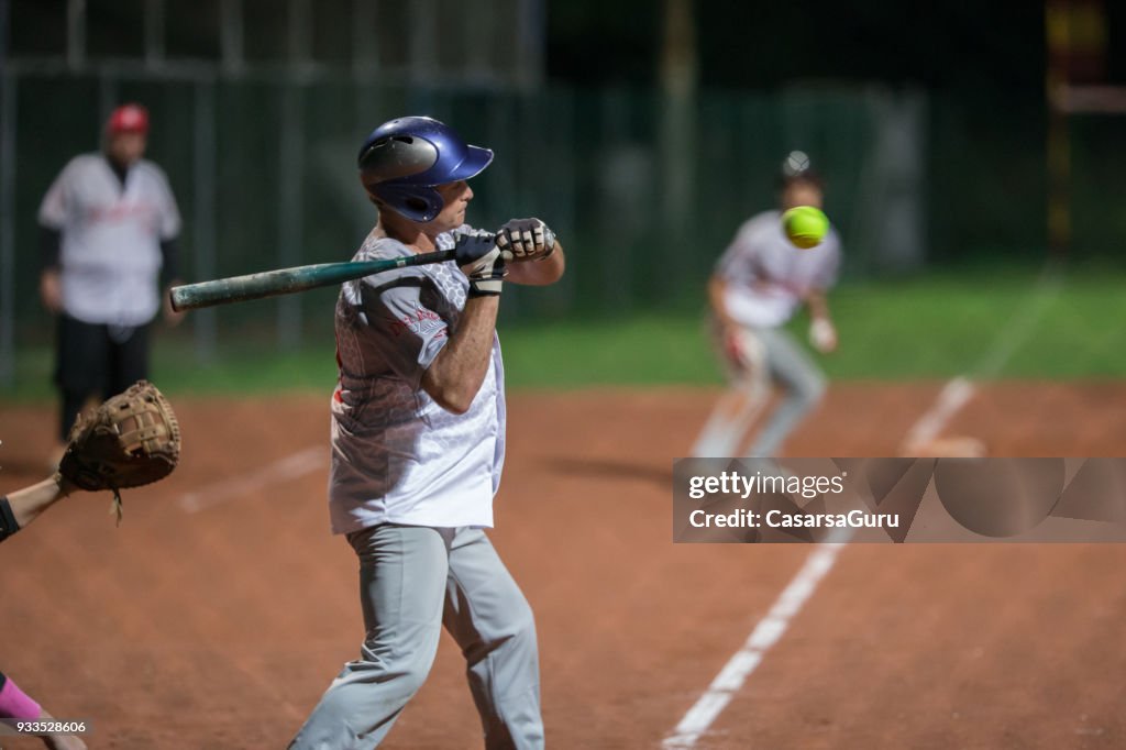 Softbal slagman proberen te raken van de bal medio lucht