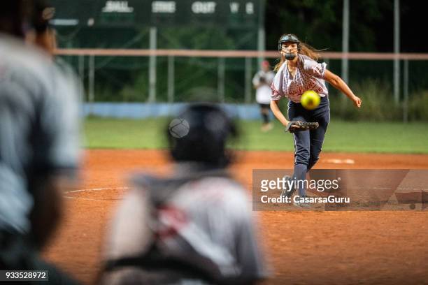 softball-pitcher den ball mitte luft betrachten - softball sport stock-fotos und bilder
