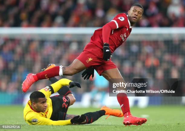 Georginio Wijnaldum of Liverpool leaps over Etienne Capoue of Watford during the Premier League match between Liverpool and Watford at Anfield on...