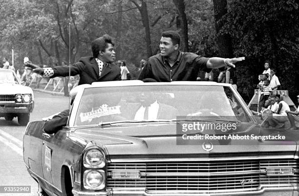 American singer James Brown and boxing champ Muhammad Ali , smile and greet parade goers while participating in the annual Bud Billiken parade,...