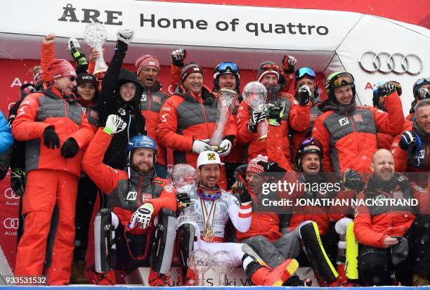 Overall Winner of the Men's Alpine Skiing World Cup Marcel Hirscher and members of team Austria celebrate on the podium with all their trophies after...