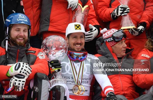 Overall Winner of the Men's Alpine Skiing World Cup Marcel Hirscher and members of team Austria celebrate on the podium with all their trophies after...