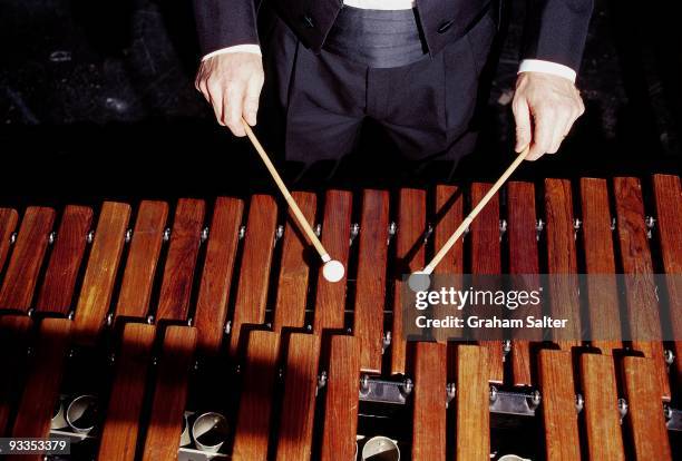 Musician plays a Marimba percussion instrument with a pair of single sticks circa 1998 in London.