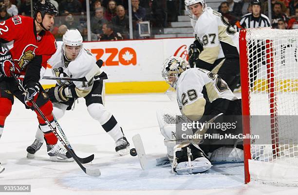 Marc-Andre Fleury of the Pittsburgh Penguins makes a save down low while teammate Christopher Bourque tries to defend against Chris Kelly of the...