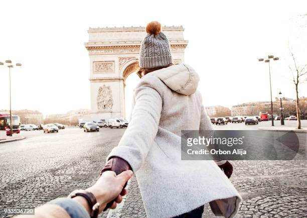 vrouw lopen in parijs, arc de triomphe - couple paris stockfoto's en -beelden
