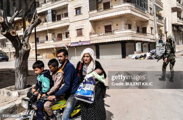 Civilians run for cover from explosions in the city of Afrin in northern Syria on March 18 after Turkish forces and their rebel allies took control...