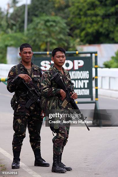 Philippine soldiers man a chechpoint along the highway following the massacre of at least 46 people, including the wife, sister and other relatives...