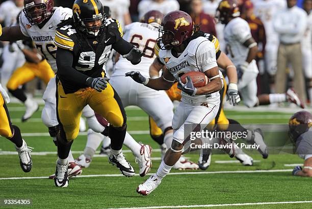 Defensive back Kevin Whaley of the Minnesota Golden Gophers runs away from Defensive lineman Adrian Clayborn of the Iowa Hawkeyes in the first half...