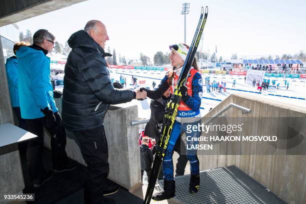 Darya Domracheva from Belarus is congratulated by King Harald V of Norway after winning the IBU Biathlon World Cup Women's 10 km Pursuit event in...