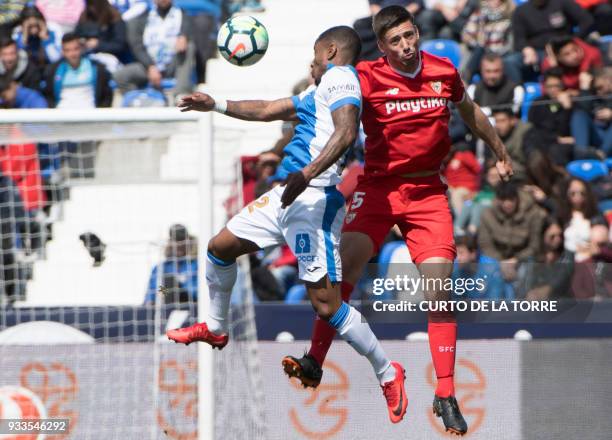 Leganes' Guadeloupean forward Claudio Beauvue jumps for the ball with Sevilla's French defender Clement Lenglet during the Spanish League football...