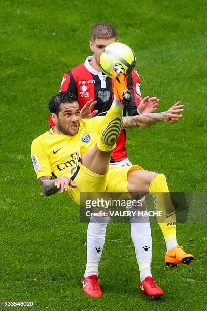 Paris Saint-Germain's Brazilian defender Dani Alves performs a bicycle kicke despite Nice's French defender Maxime Le Marchand during the French L1...