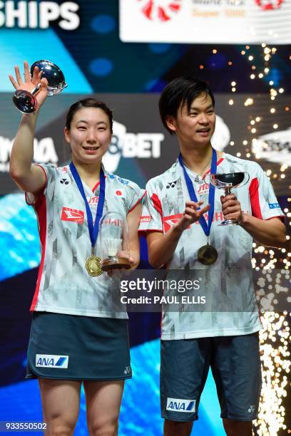 Japan's Yuta Watanabe and Japan's Arisa Higashino celebrate on the podium with their trophies after winning the mixed doubles final against China's...