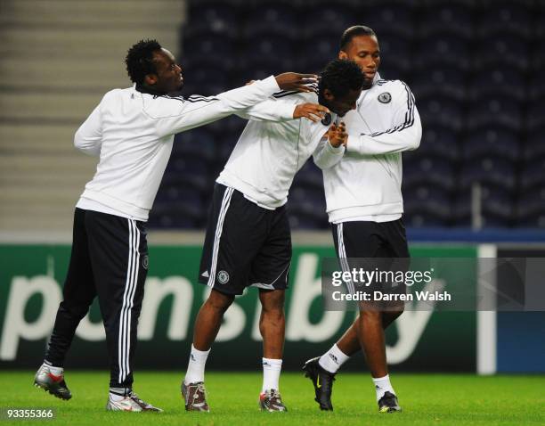 Michael Essien jokes with John Obi Mikel and Didier Drogba during the Chelsea training session, prior to UEFA Champions League Group D match against...