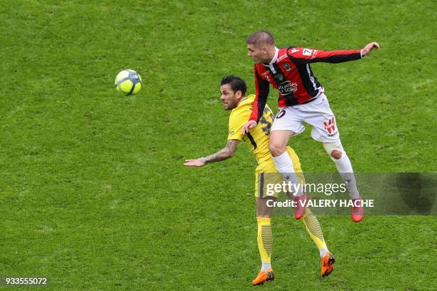 Paris Saint-Germain's Brazilian defender Dani Alves and Nice's French defender Maxime Le Marchand go for a header during the French L1 football match...