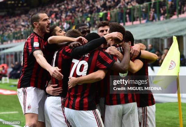 Milan's German midfielder Hakan Calhanoglu is congratulated by teammates after scoring during the Italian Serie A football match AC Milan vs AC...