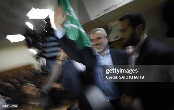 Flanked by bodyguards, Hamas leader Ismail Haniya waves to hunderds of Palestinian Muslim pilgrims leaving the Gaza Strip through the Rafah crossing...