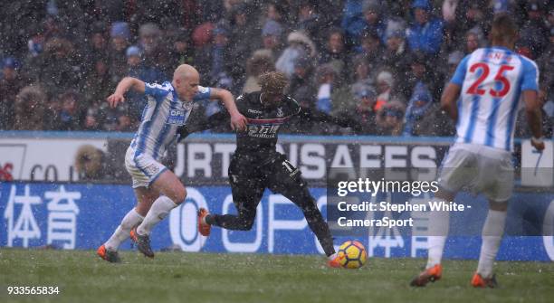 Crystal Palace's Wilfried Zaha and Huddersfield Town's Aaron Mooy during the Premier League match between Huddersfield Town and Crystal Palace at...