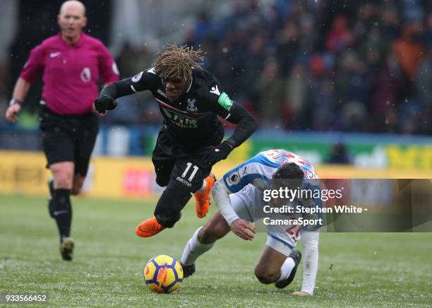 Crystal Palace's Wilfried Zaha is tackled by Huddersfield Town's Christopher Schindler during the Premier League match between Huddersfield Town and...