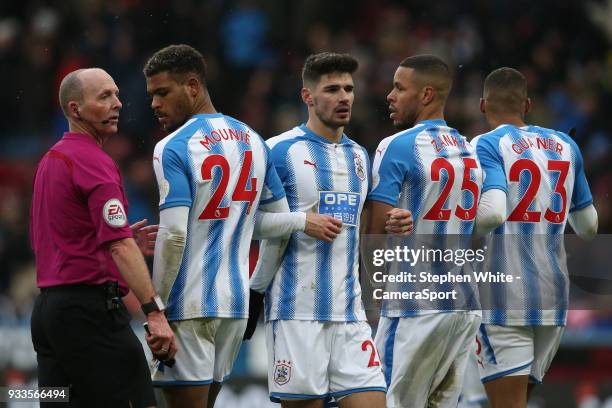 Referee Mike Dean positions Huddersfield Town's Steve Mounie, Christopher Schindler, Mathias Zanka Jorgensen and Collin Quaner the correct distance...