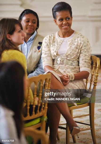 First Lady Michelle Obama sits with a group of young women from the White House leadership and mentoring program during a presentation on the history...