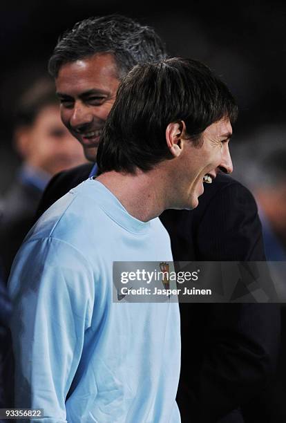 Lionel Messi of FC Barcelona smiles backdropped by Inter Milan coach Jose Mourinho as prepares to watch from the sidelines due to an injury prior to...