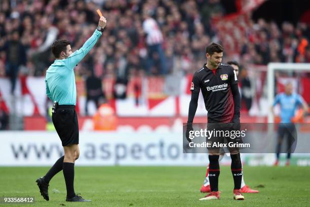 Referee Harm Osmers shows the red card to Lucas Alario of Leverkusen during the Bundesliga match between 1. FC Koeln and Bayer 04 Leverkusen at...