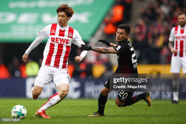 Yuya Osako of 1.FC Koeln and Charles Aranguiz of Bayer Leverkusen battle for the ball during the Bundesliga match between 1. FC Koeln and Bayer 04...