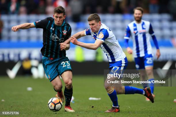 Pierre-Emile Hojbjerg of Southampton battles with Ryan Colclough of Wigan during The Emirates FA Cup Quarter Final match between Wigan Athletic and...