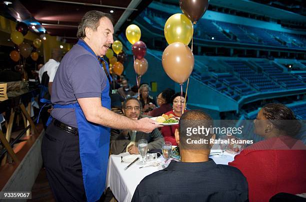 Ernie Grunfeld, President of the Washington Wizards, serves lunch to a table of senior DC residens as part of the Thanksgiving Lunch at Verizon...