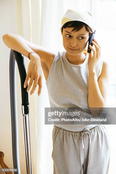 woman taking break from housework for phone call, looking away - jogging pants stock pictures, royalty-free photos & images