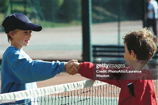 girls shaking hands at net on tennis court - respect stockfoto's en -beelden