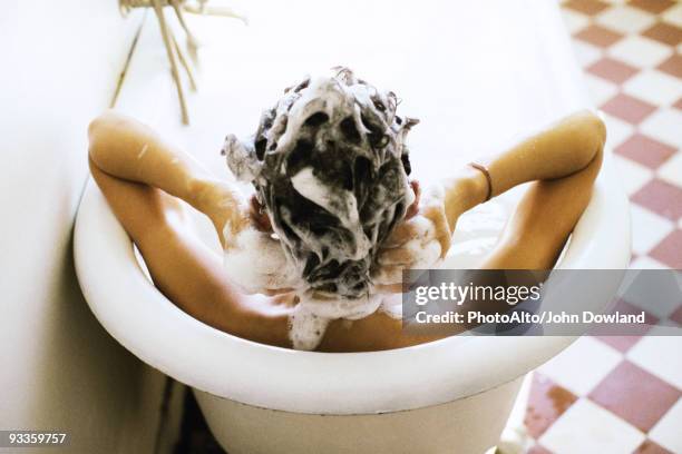 woman in bath shampooing hair - shampoo stock pictures, royalty-free photos & images