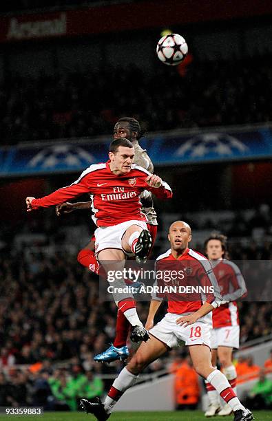 Arsenal's Dutch defender Thomas Vermaelen leaps to head the ball under a challenge from Standard Liege's French player Eliaquim Mangala during the...