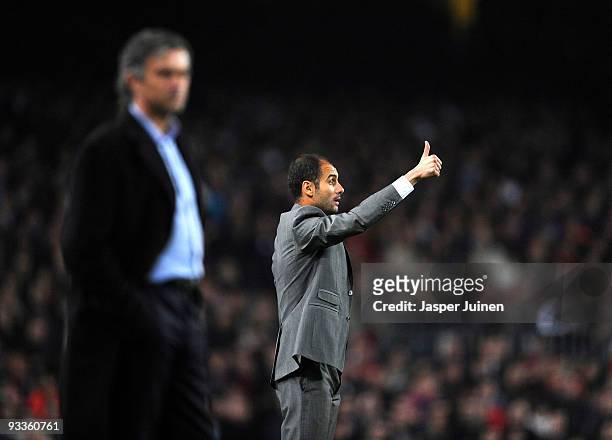 Coach Josep Guardiola of FC Barcelona gestures thumbs up to his players flanked by coach Jose Mourinho of Inter Milan during the UEFA Champions...