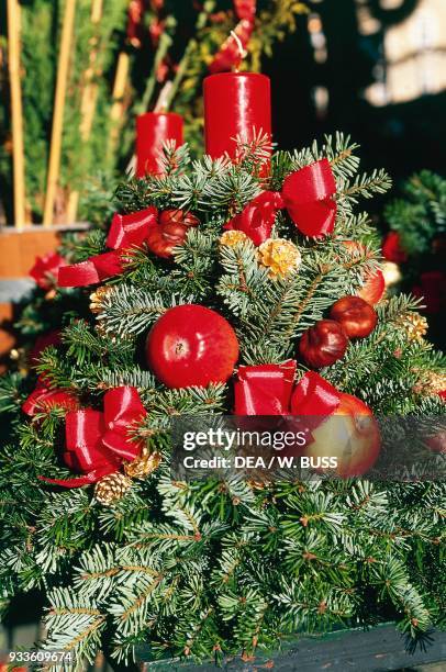 Centerpiece with candles, apples and pine branches, Christmas decoration, Domplatz Christmas market, Salzburg, Austria.