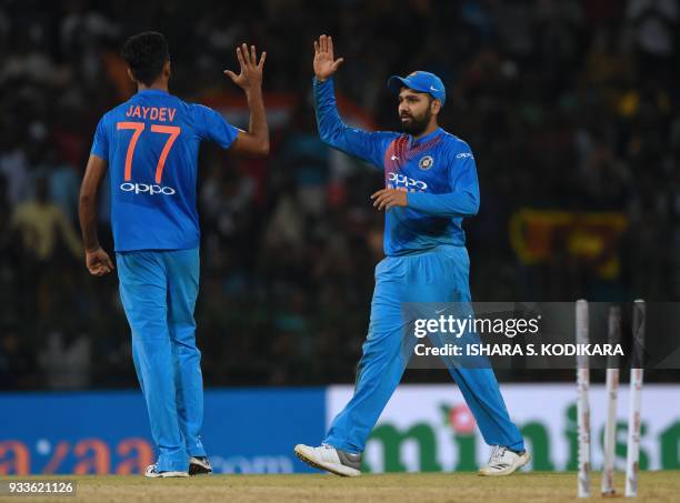 Indian cricketer Jaydev Unadkat and team captain Rohit Sharma celebrate after the dismissal of Bangladeshi cricketer Sabbir Rahman during the final...