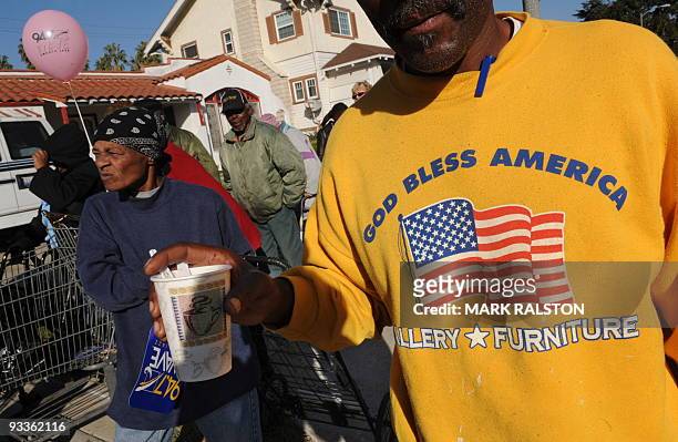 People wait amongst a group of 10,000 low-income and needy people who lined up to receive free Thanksgiving turkeys and fixings distributed by the...