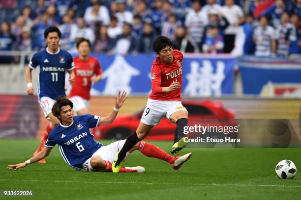 Yuki Muto of Urawa Red Diamonds and Takahiro Ogihara of Yokohama F.Marinos compete for the ball during the J.League J1 match between Urawa Red...