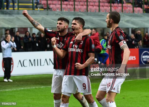 Milan's Portuguese forward Andre Silva celebrates after scoring AC Milan's Italian forward Patrick Cutrone and AC Milan's Captain Italian defender...