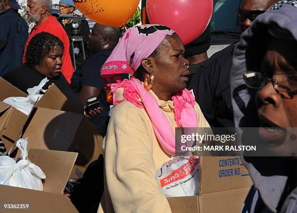 Three of a group of 10,000 low-income and needy people who lined up to receive free Thanksgiving turkeys and fixings distributed by the Jackson...