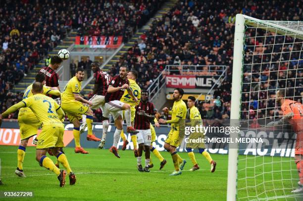 Milan's Portuguese forward Andre Silva heads the ball during the Italian Serie A football match AC Milan vs AC Chievo at the San Siro stadium in...