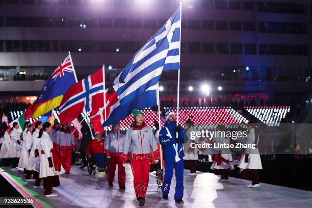 Athletes carry their national flags to take part in the closing ceremony of the 2018 Winter Paralympics during the closing ceremony of the...