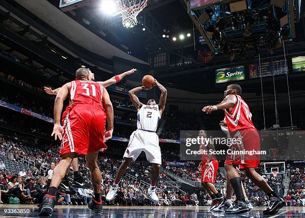 Joe Johnson of the Atlanta Hawks goes up for a shot against Shane Battier and Carl Landry of the Houston Rockets during the game at Philips Arena on...