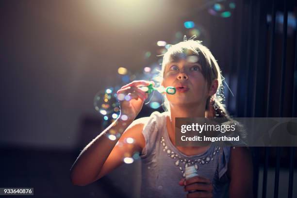 girl having fun blowing bubbles - child bubble stock pictures, royalty-free photos & images